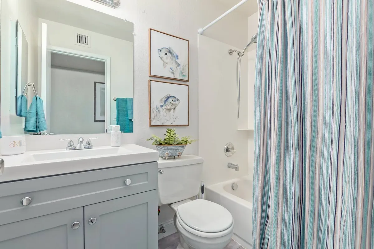 A modern bathroom with a sleek vanity sink, a spacious shower area, and tasteful artwork on the wall. The design is contemporary yet inviting, ideal for starting or ending the day in comfort.